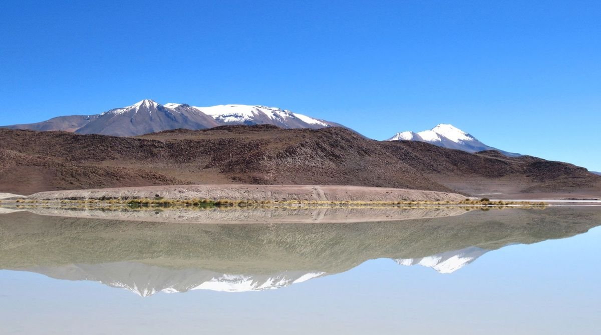 Mountains reflected in the flooded salt flat of Salar de Uyuni, Bolivia