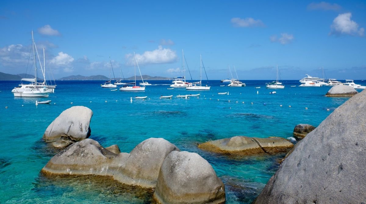 Granite boulders and yachts in clear turquoise water in the British Virgin Islands