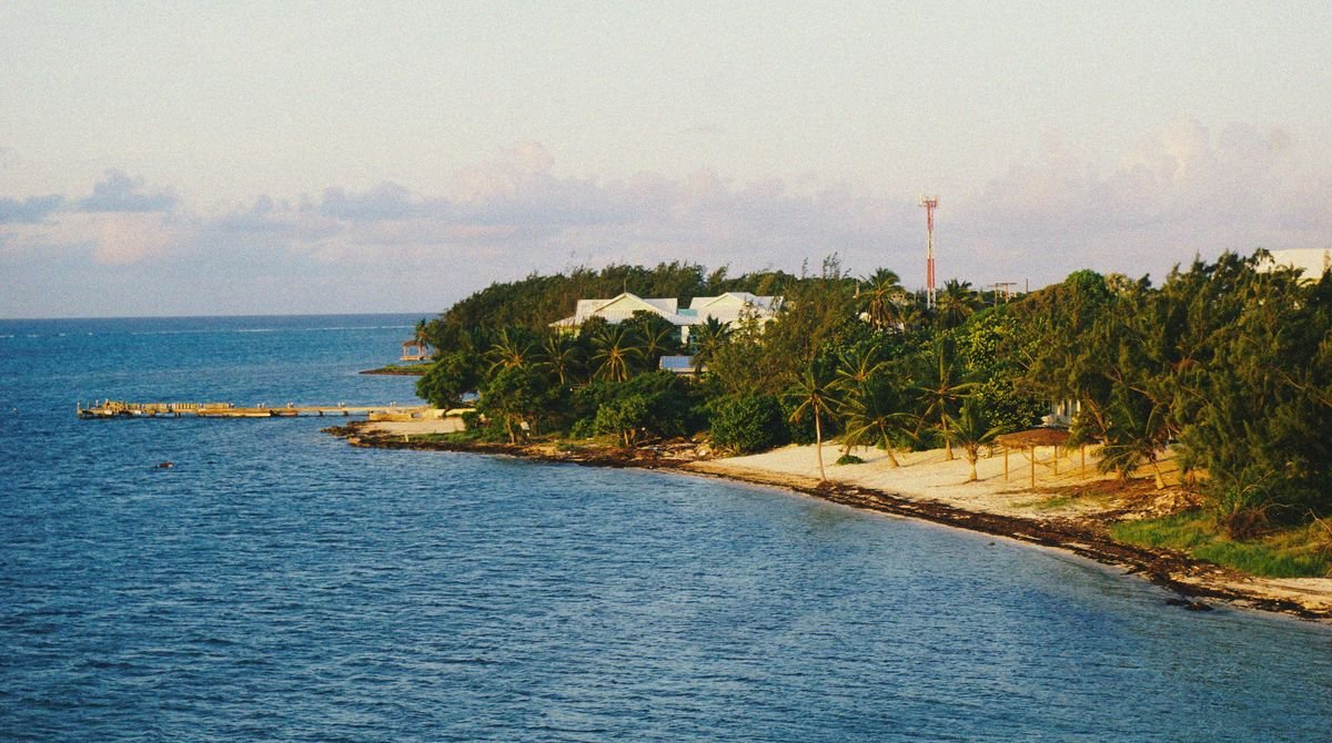 Calm sea and a green headland on the coast of the Cayman Islands