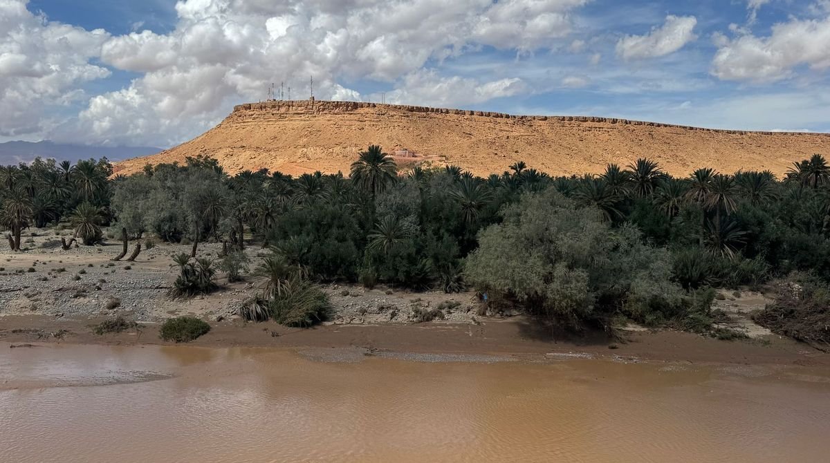 Sandy riverbed below a flat-topped hill in the Sahel