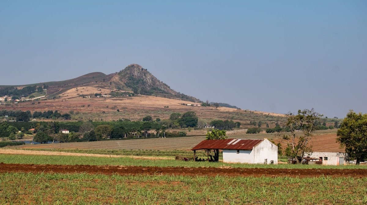 Farmland below a rocky hill in the Eswatini countryside