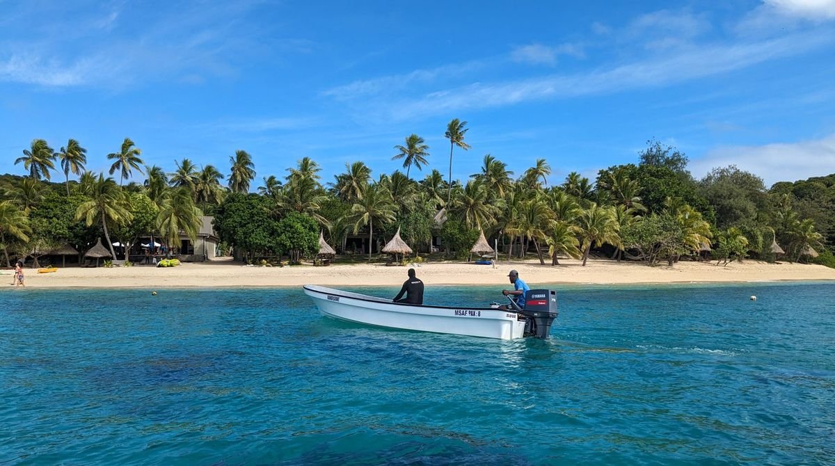 Palm-fringed beach and clear blue water in Fiji