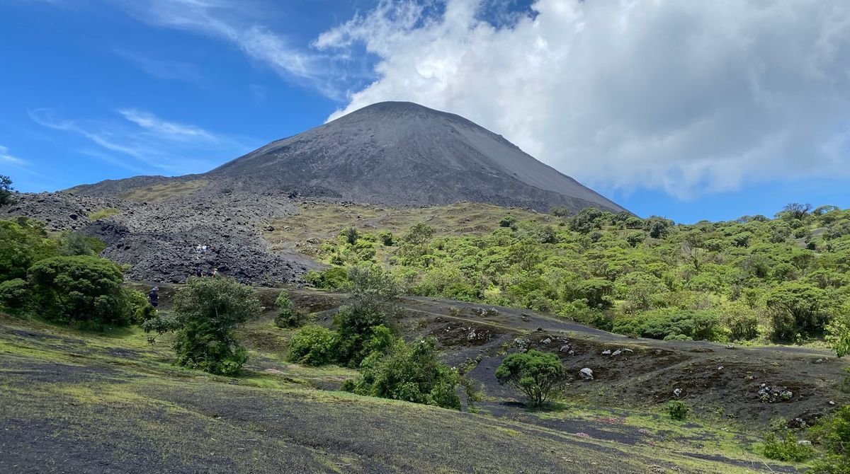 Green volcanic cone rising above the island landscape