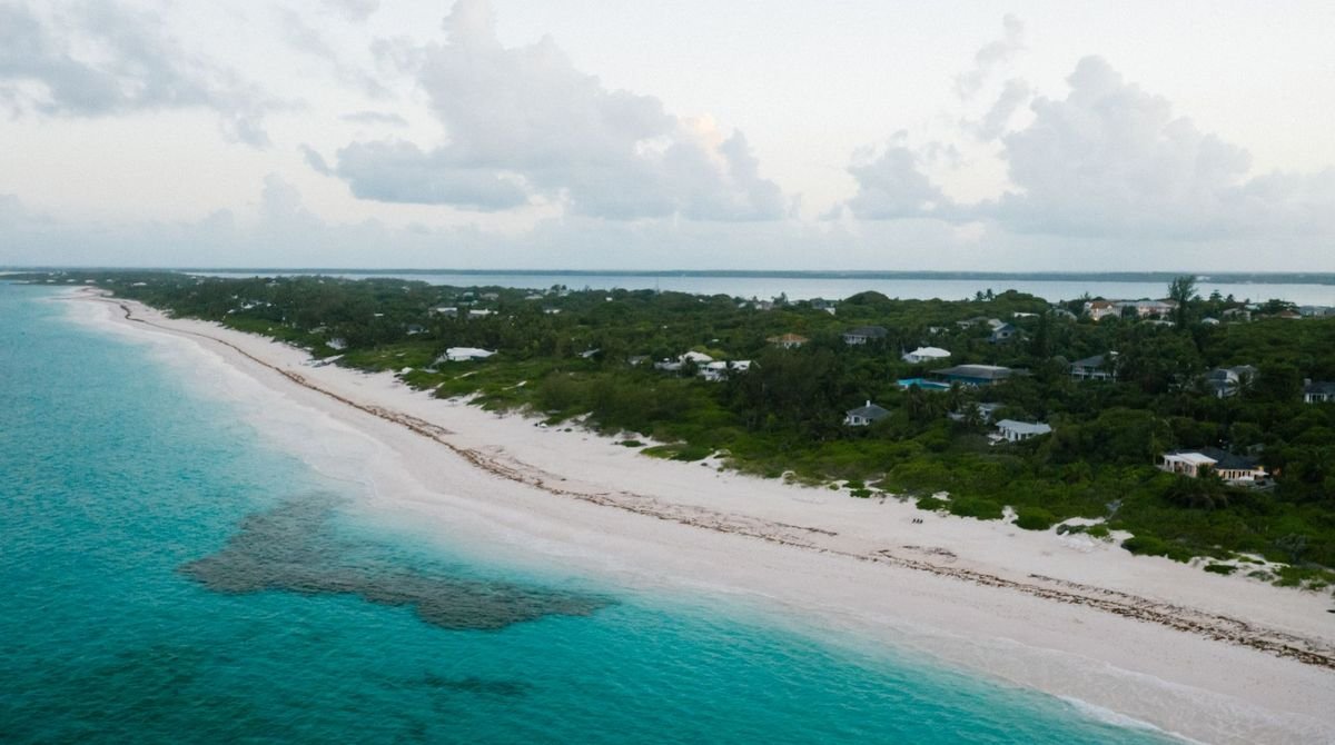 Long white beach and turquoise water seen from above in the Turks and Caicos
